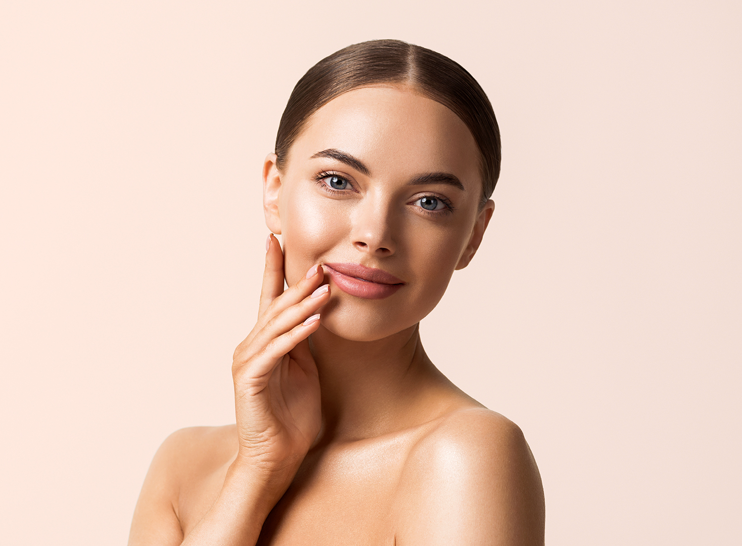 Woman with smooth, radiant skin resting her hand against her cheek